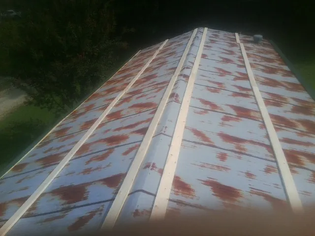 Rusted metal roof panels with new wood purlins before replacement — Storm Damage Roof Repair in Belmont by Roofing Brothers